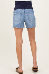 woman wearing light blue maternity shorts with a distressed hem and a dark navy waistband, no baby bump visible