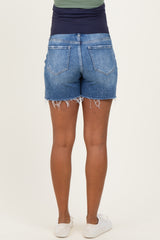 woman wearing maternity blue denim shorts with frayed hems, showing a smooth waistband and back pockets