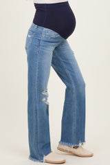 woman wearing light blue distressed maternity jeans with a black panel and a visible baby bump