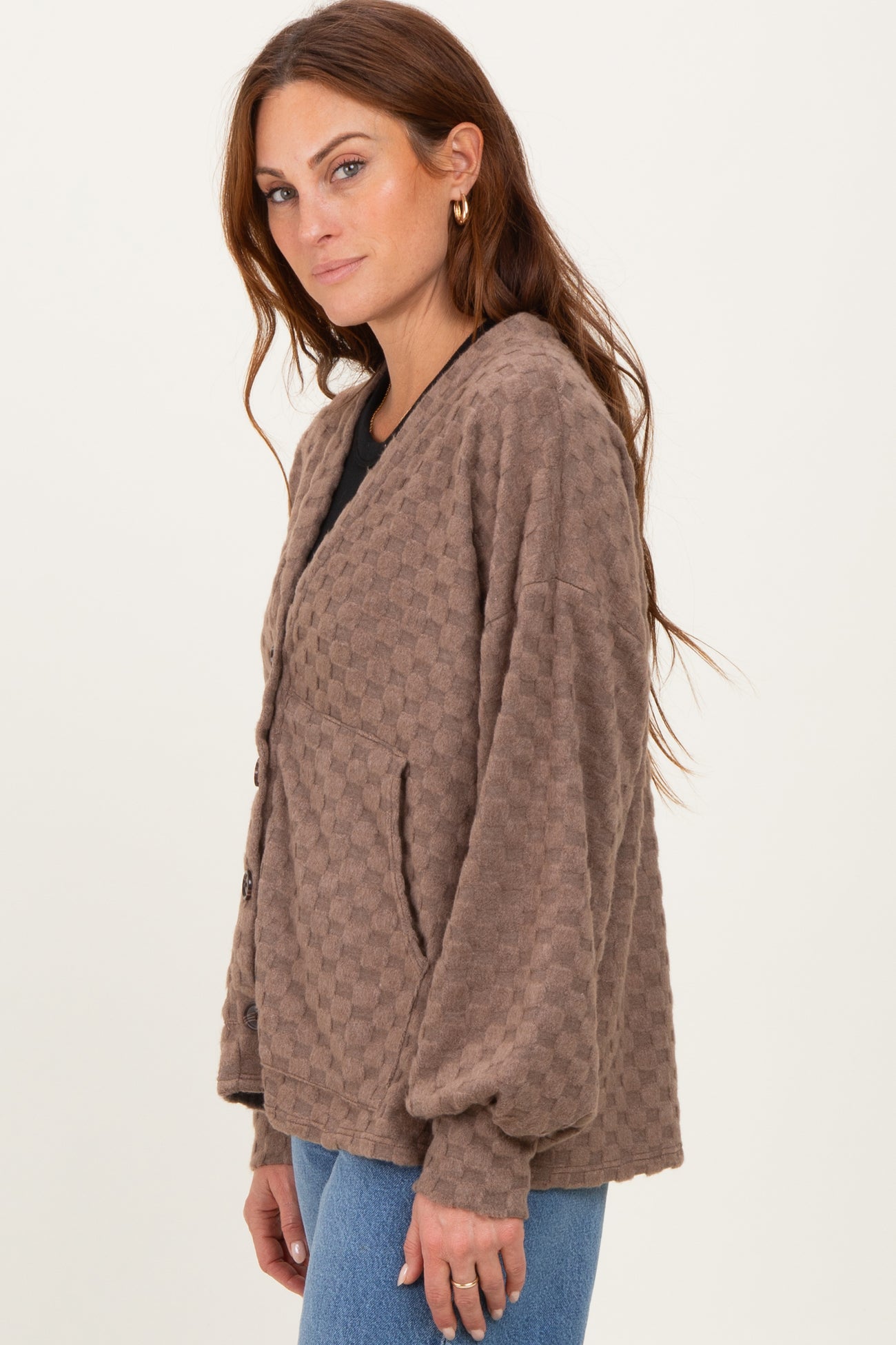 woman wearing a brown textured button-up cardigan with oversized sleeves and front pockets