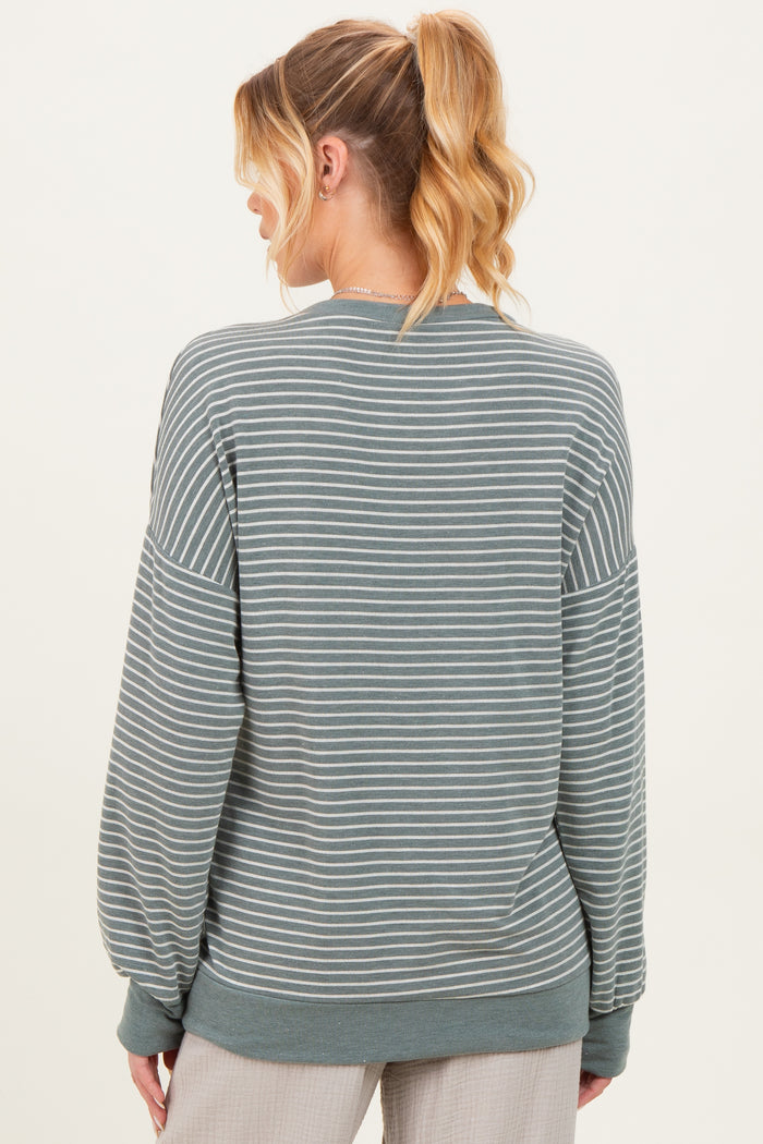 woman wearing a green striped maternity sweatshirt with long sleeves, shown from the back