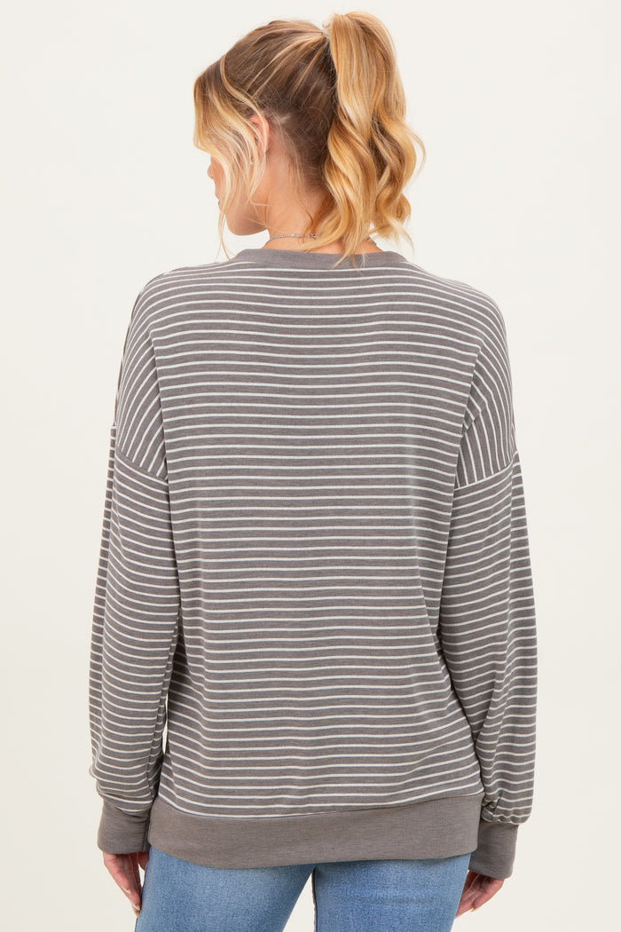 woman wearing a gray striped maternity sweatshirt seen from the back, with loose fit and long sleeves