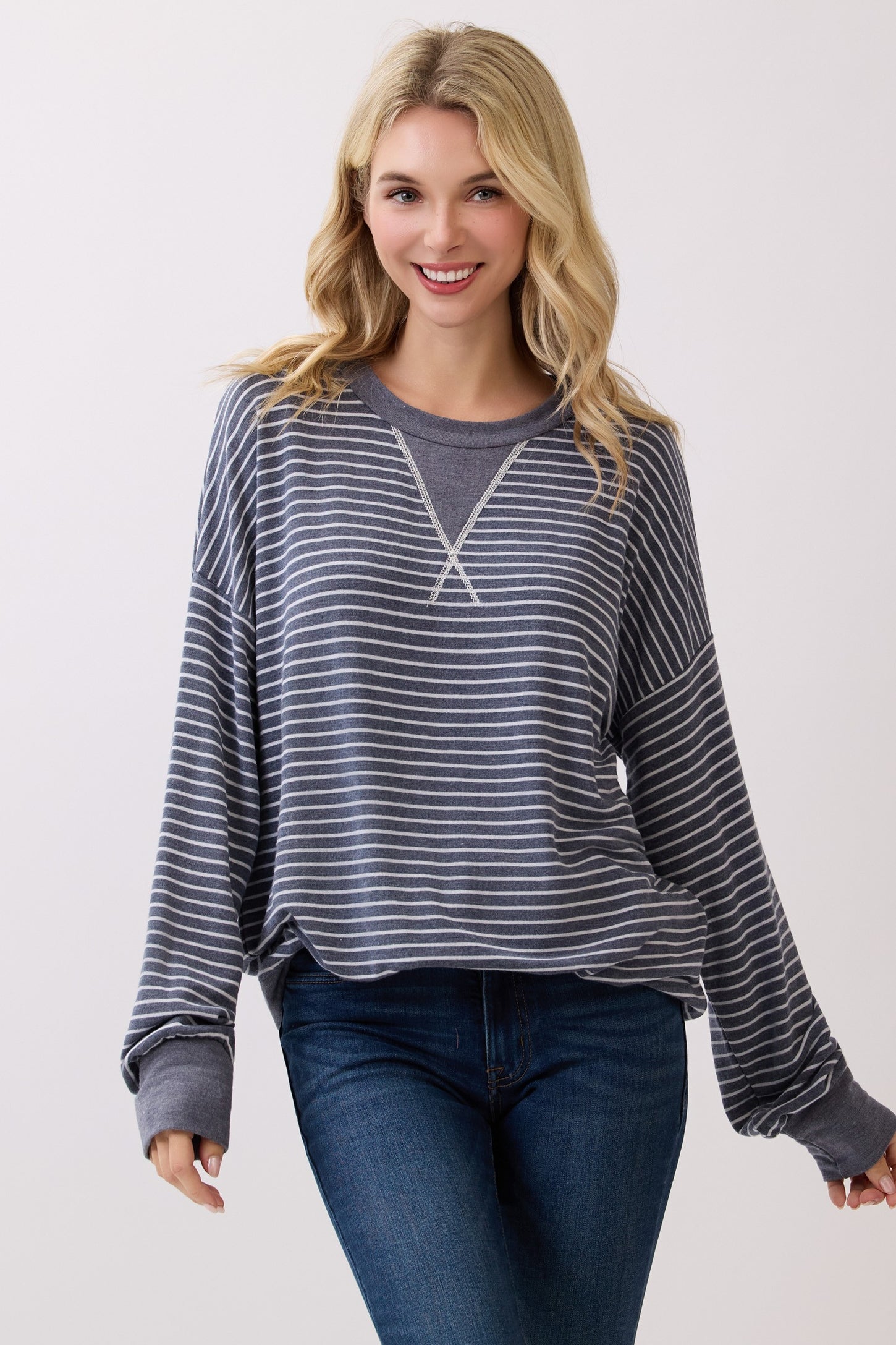 woman wearing a navy blue and white striped long sleeve sweatshirt with a relaxed fit and wide sleeves