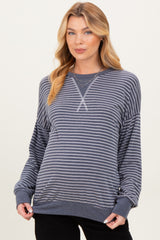woman wearing a navy and white striped maternity sweatshirt with a relaxed fit and long sleeves, showing her baby bump