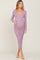 woman wearing a dusty rose long sleeve ribbed maternity dress and holding her baby bump