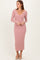 woman wearing a light pink ribbed long sleeve midi dress with a deep v-neckline and side-slit detailing