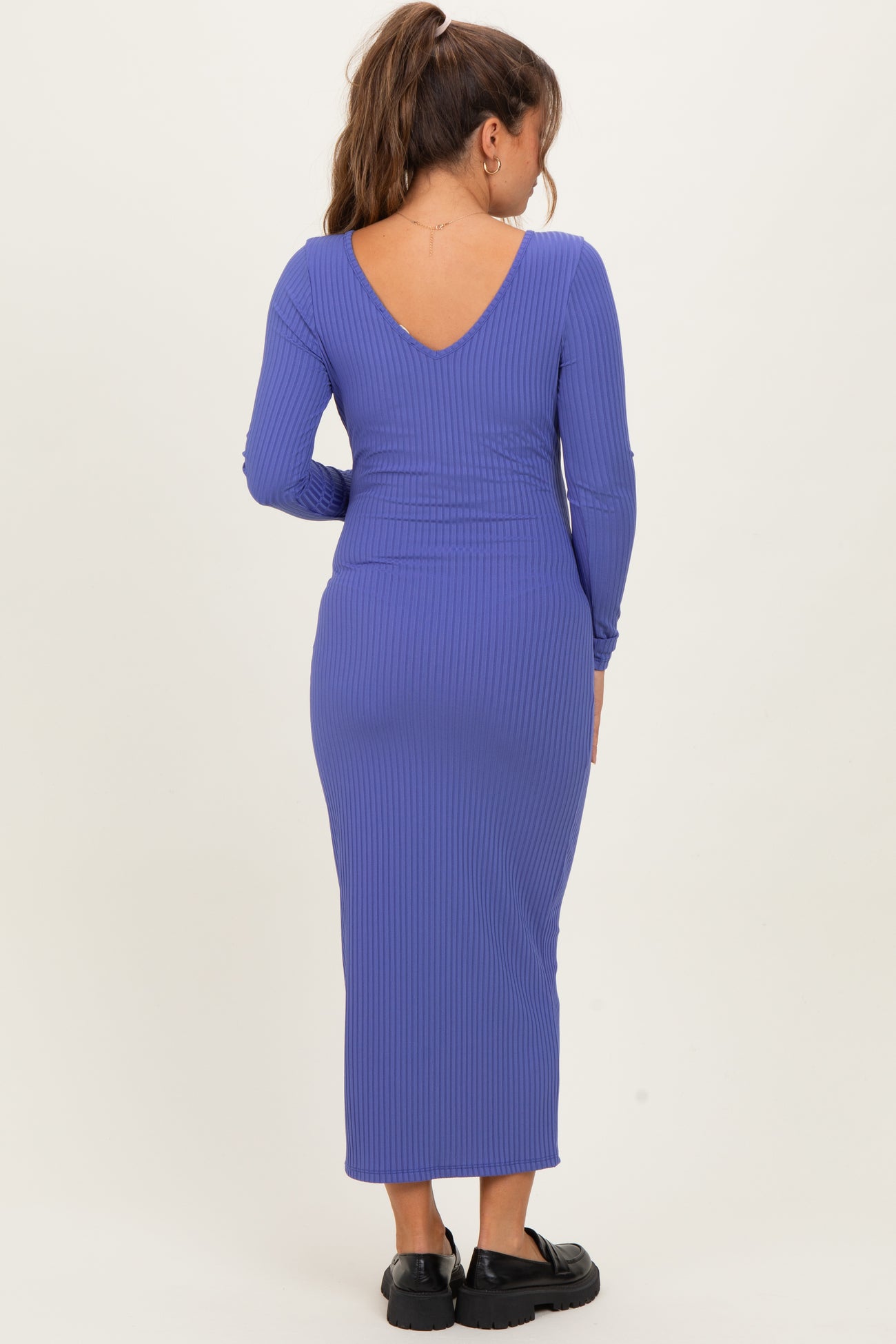 woman wearing a purple ribbed maternity dress with a v-back and long sleeves
