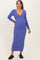 woman wearing a purple ribbed maternity dress with a deep V-neck and long sleeves, showing her baby bump