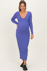 woman wearing a purple ribbed long sleeve maternity dress with a deep V-neck and showing her baby bump