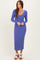 woman wearing a long sleeve ribbed purple midi dress and white sandals