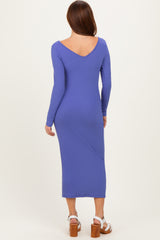 woman wearing a form-fitting ribbed purple midi dress with long sleeves and a v-back design