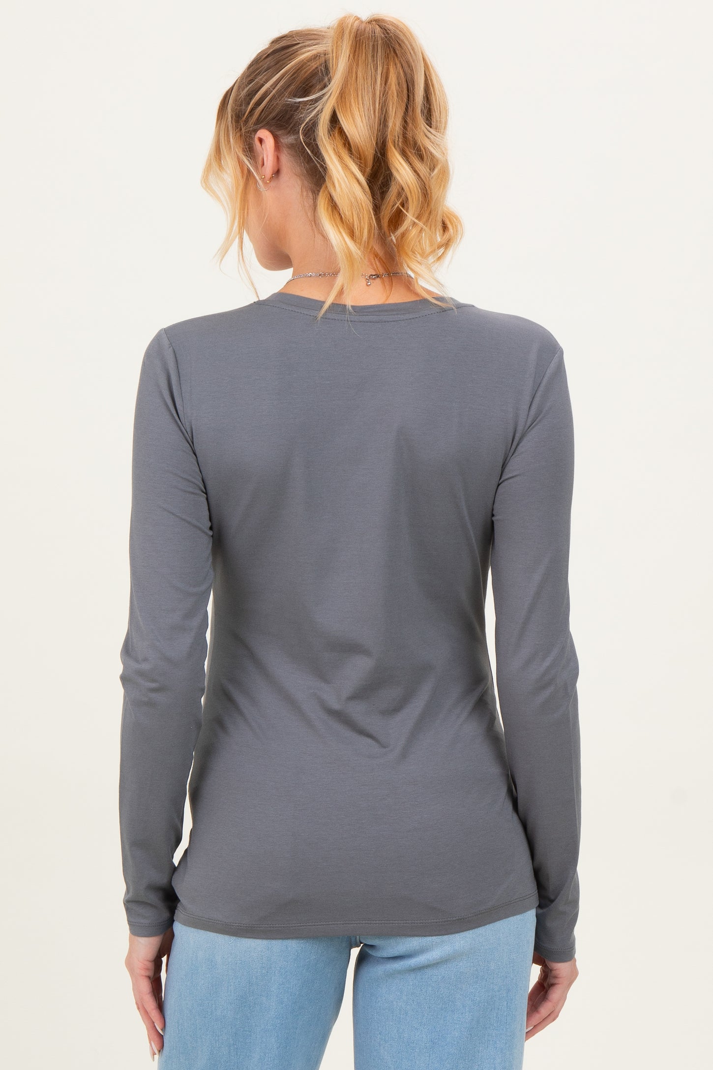 woman wearing a gray long sleeve maternity top viewed from the back