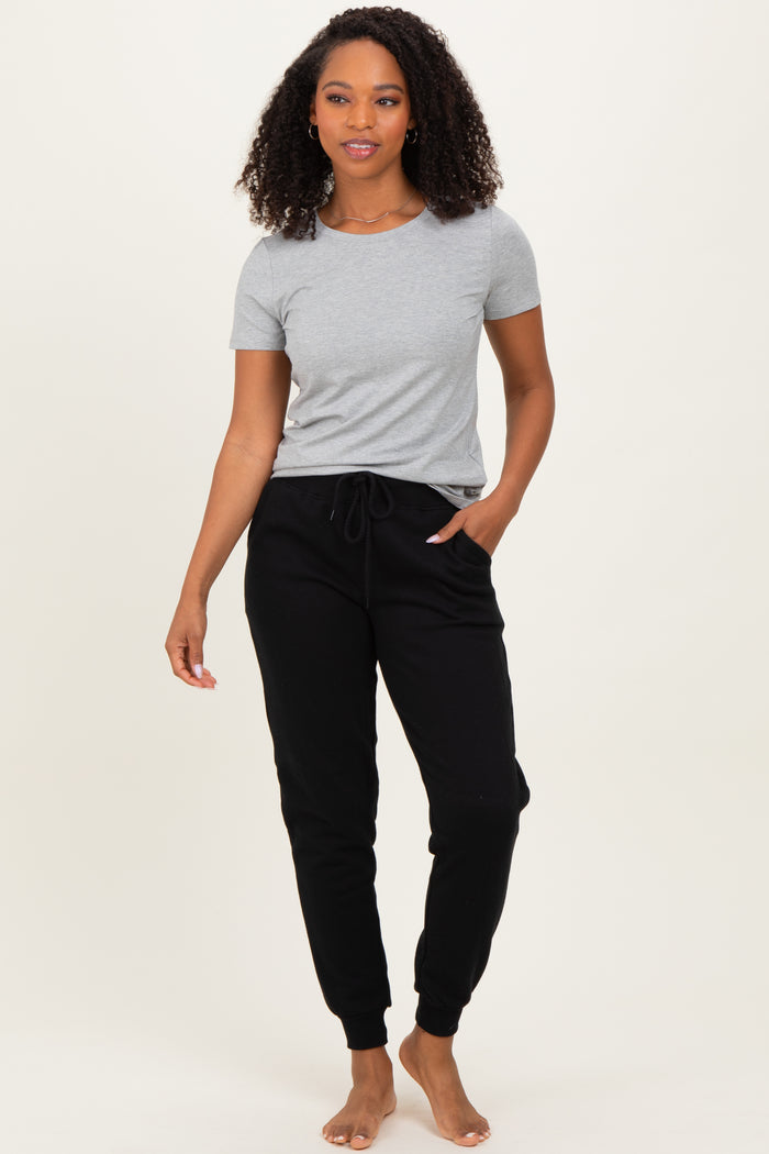 woman wearing a gray short sleeve t-shirt and black jogger pants with a drawstring waist