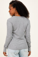 woman wearing a gray long sleeve ribbed top, viewed from the back with a relaxed fit and styled hair