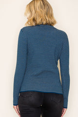 woman wearing a dark teal and white striped long sleeve top, viewed from the back, paired with black jeans