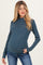 woman wearing a navy and teal striped maternity top with long sleeves and a fitted look, showing her baby bump