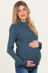 woman wearing a navy and white striped maternity top and holding her baby bump