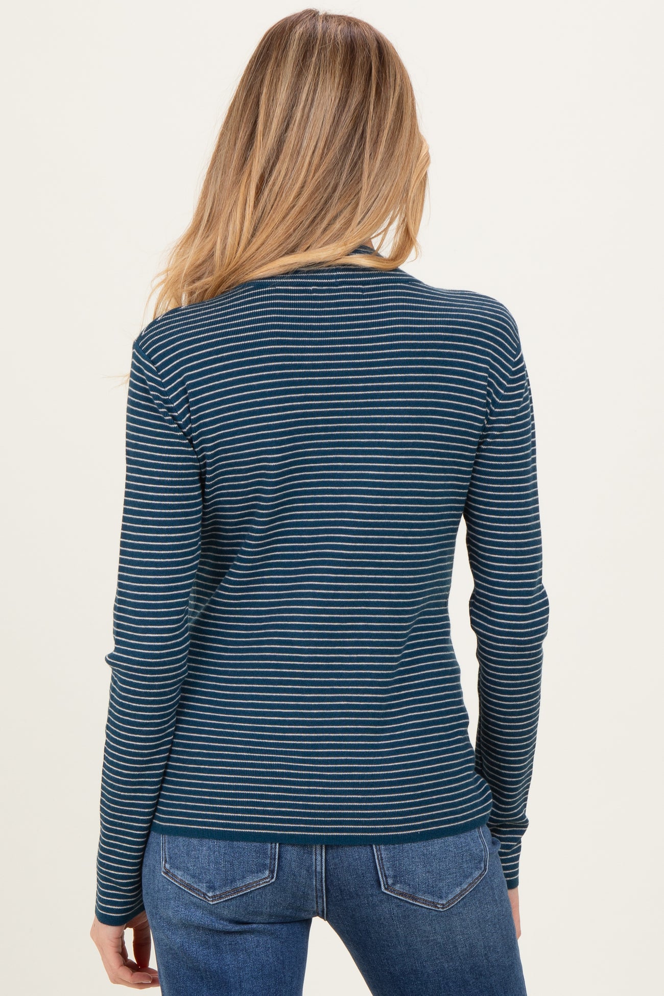 woman wearing a navy blue and teal striped long sleeve maternity top with a fitted style