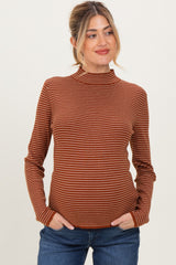 woman wearing a rust striped maternity sweater with a mock neck and a relaxed fit