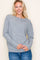 woman wearing a gray long sleeve sweater with a relaxed fit and light blue jeans