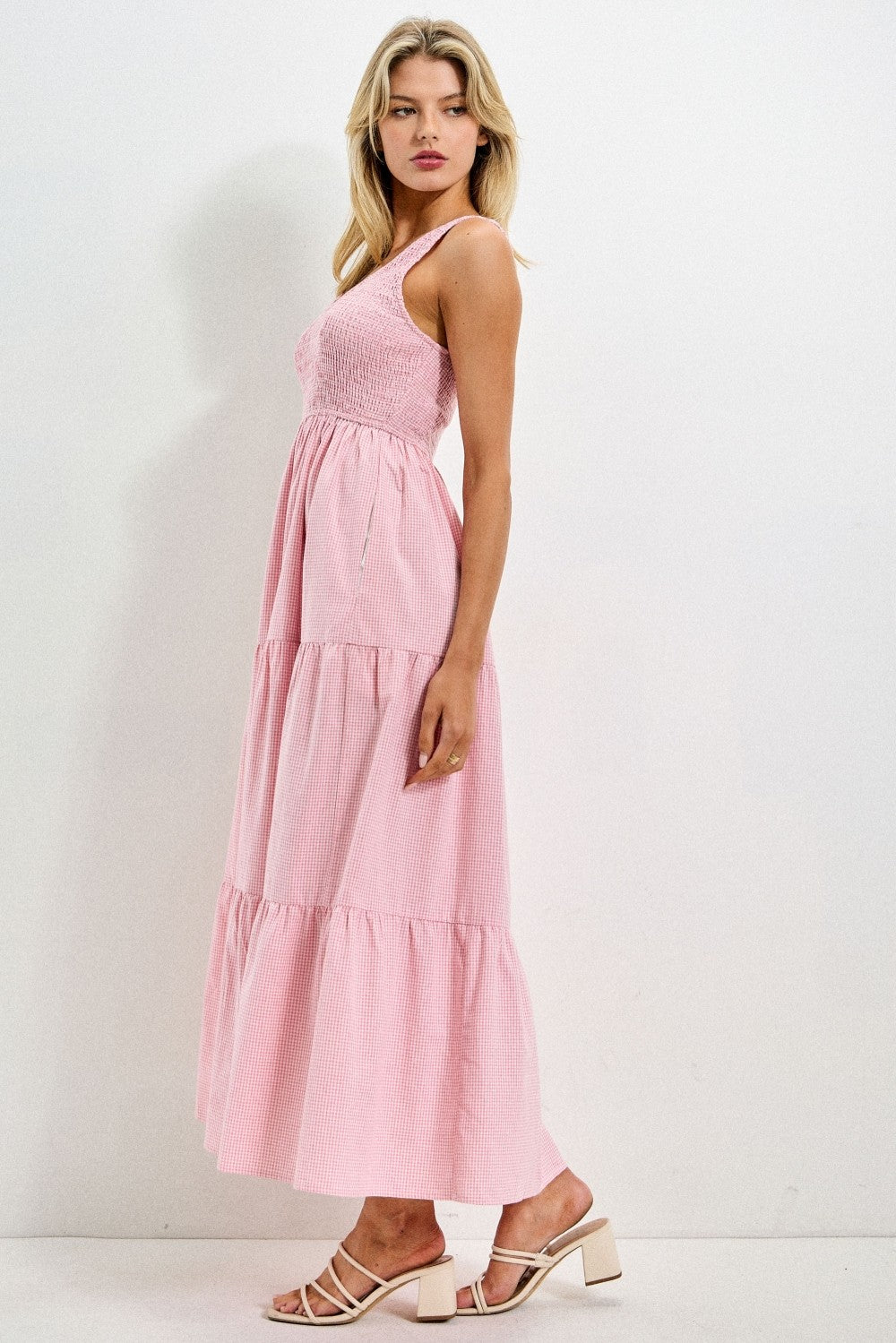 woman wearing a pink tiered maxi dress with a smocked bodice and strappy sandals