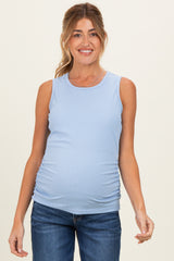woman wearing a light blue sleeveless maternity top with ribbed texture and gathered detailing, showing her baby bump