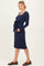 woman wearing a navy blue long sleeve maternity dress with a tie at the waist and showing her baby bump