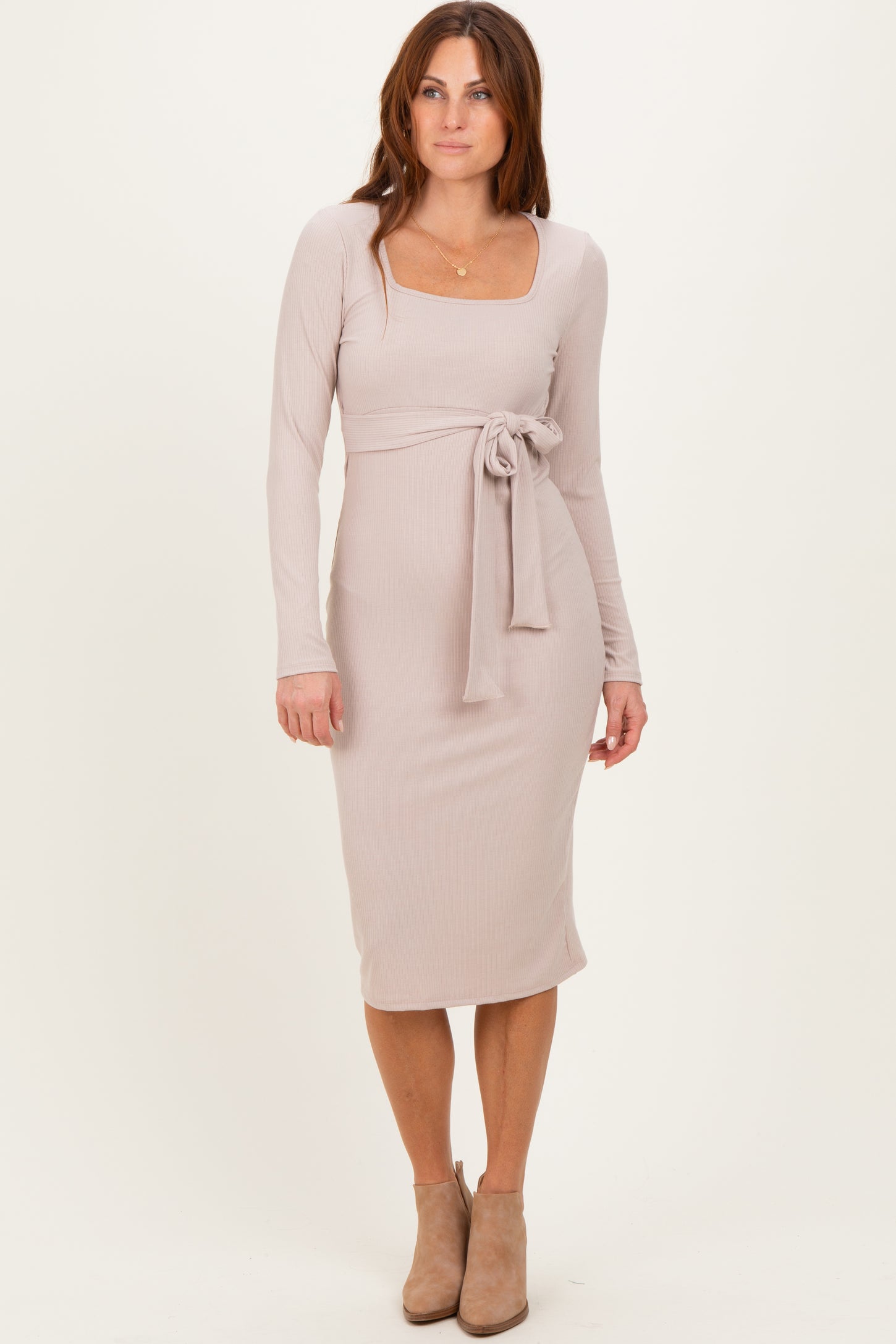 woman wearing a light taupe long sleeve ribbed dress with a square neckline and a tied waist detail