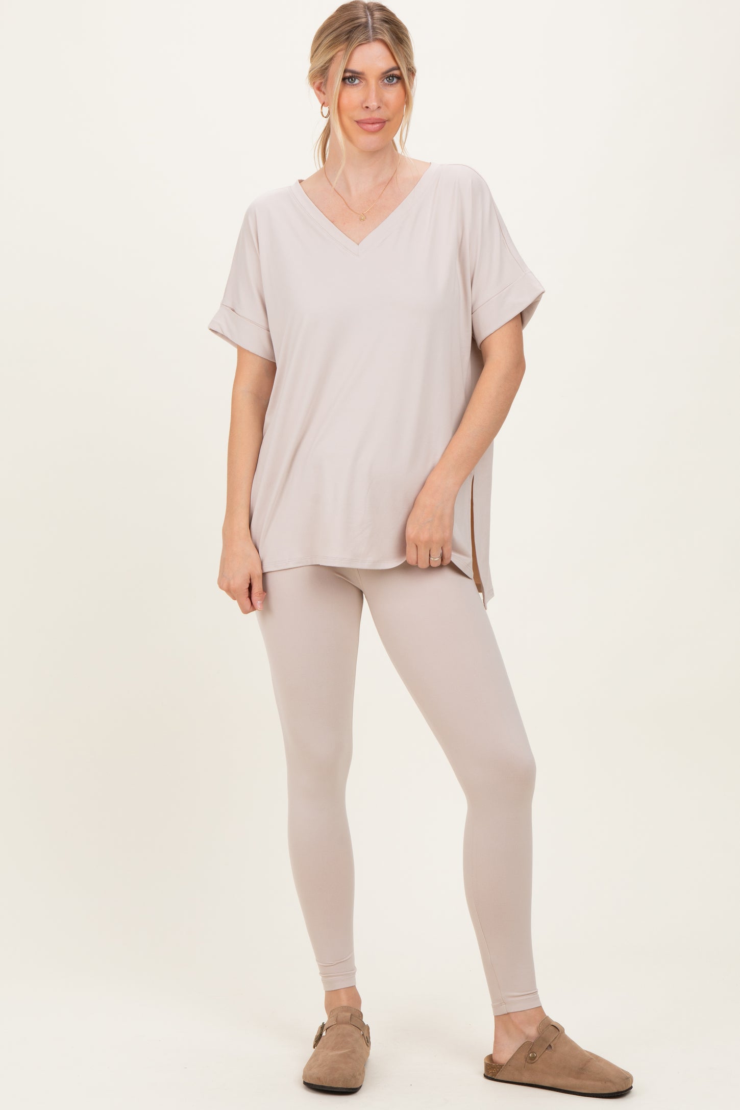 woman wearing a light beige v-neck top with short sleeves and matching fitted leggings