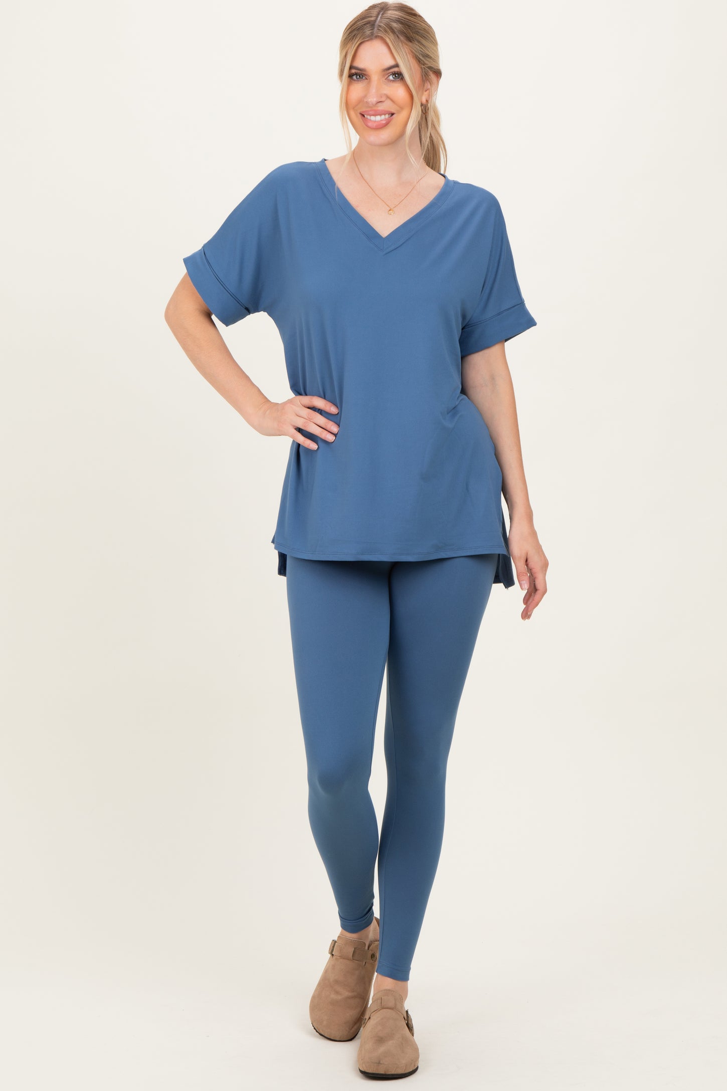 woman wearing a blue v-neck short sleeve top with rolled sleeves and matching leggings