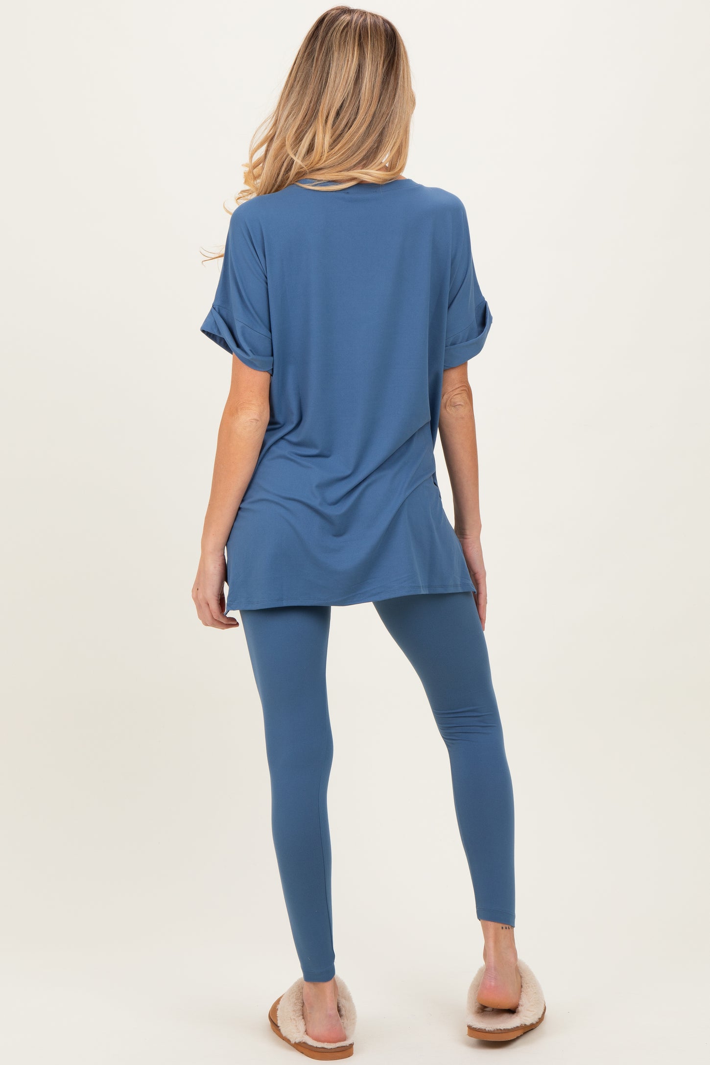 woman wearing a blue oversized maternity top and matching leggings, showing a comfortable and casual look from the back