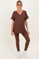 woman wearing a brown v-neck maternity top and matching leggings with a baby bump visible