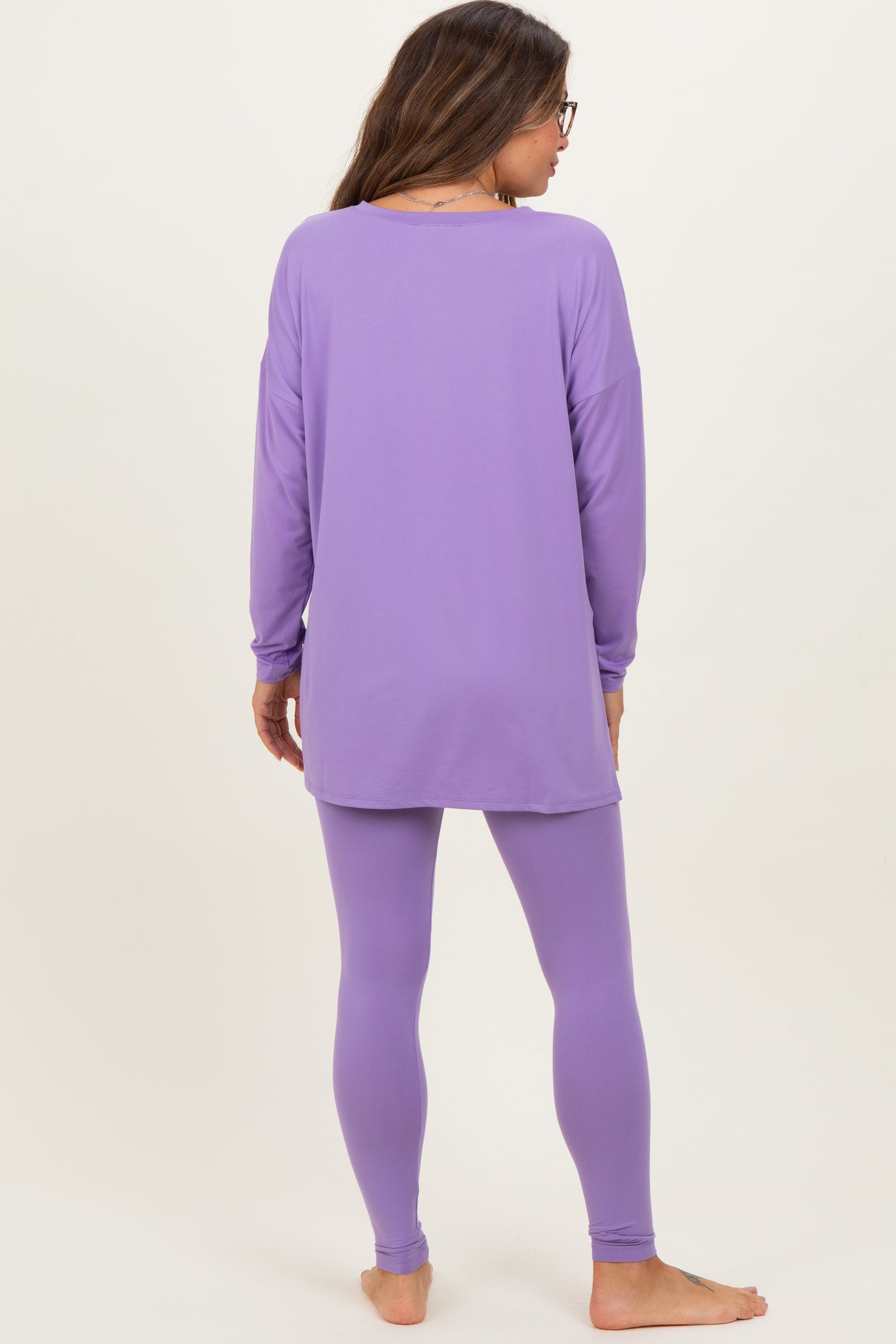 woman wearing a long sleeve lavender maternity top and matching leggings, showing a relaxed fit from the back