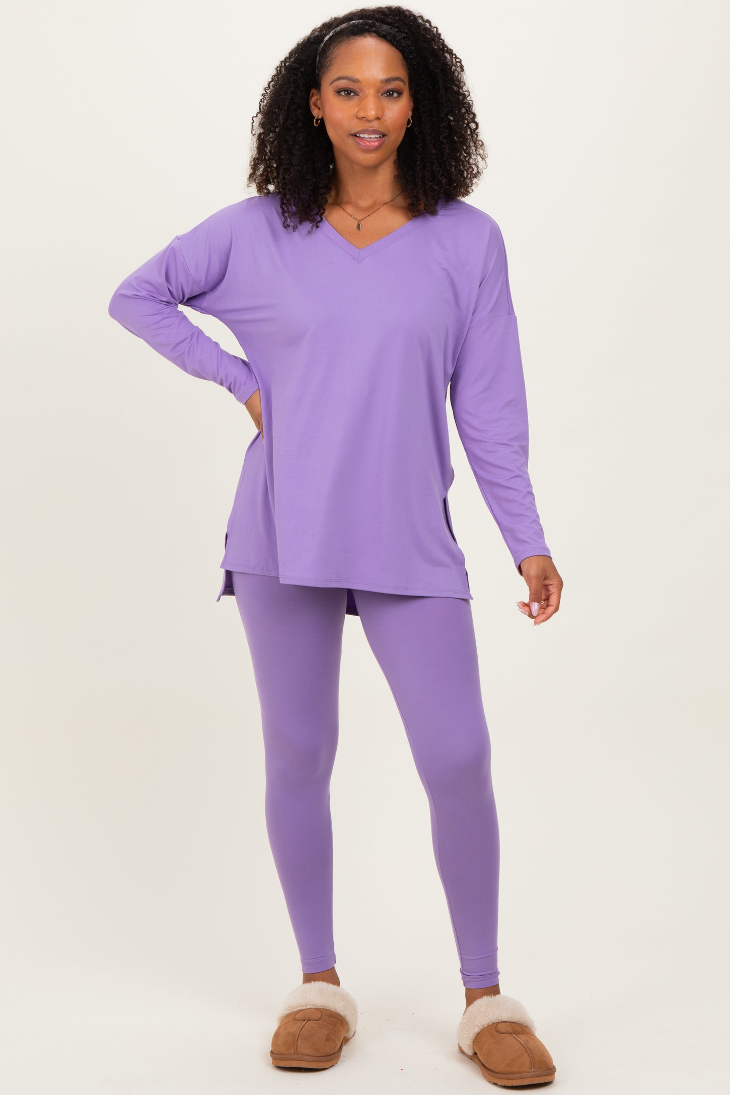 woman wearing a lavender long sleeve tunic top and matching leggings, styled with cozy slippers
