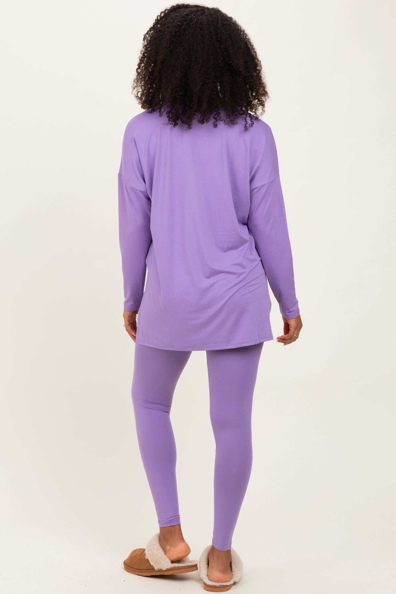woman wearing a long sleeve purple top and matching purple leggings, viewed from the back
