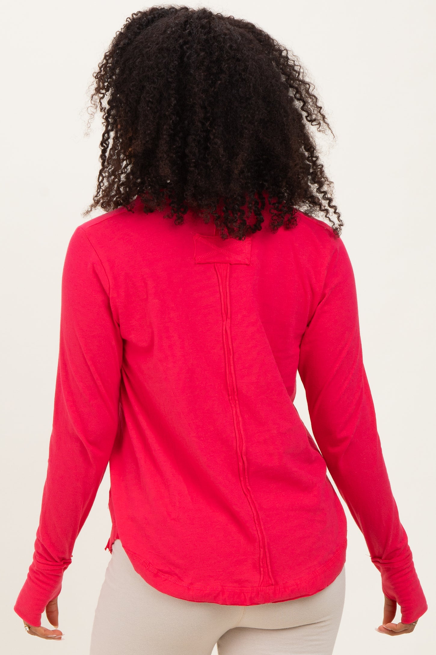 woman wearing a hot pink long sleeve shirt with a back seam detail and relaxed fit