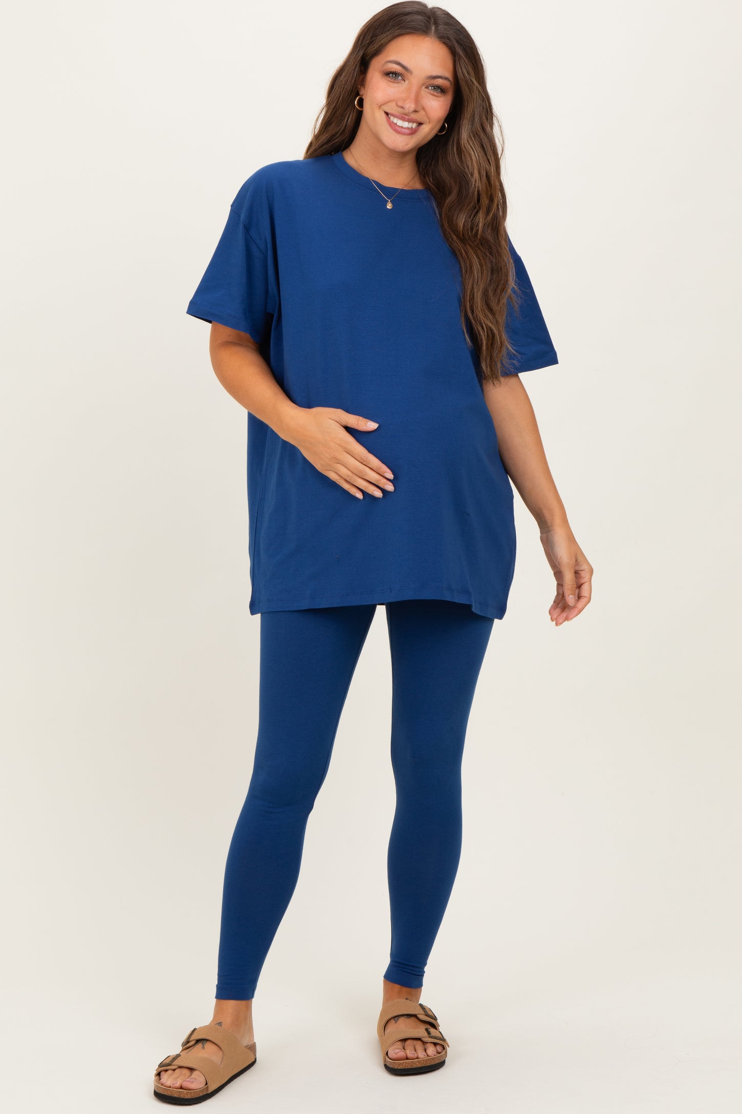woman wearing a navy blue oversized t-shirt and matching leggings, showing baby bump, styled for maternity wear