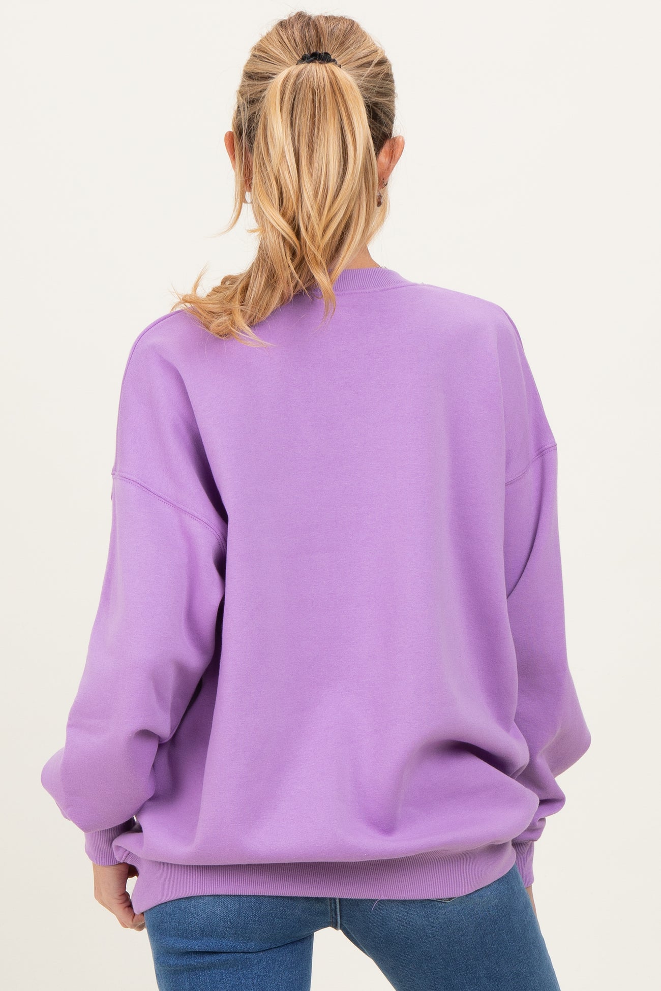 woman wearing a lavender oversized maternity sweatshirt, viewed from the back, with long sleeves and relaxed fit