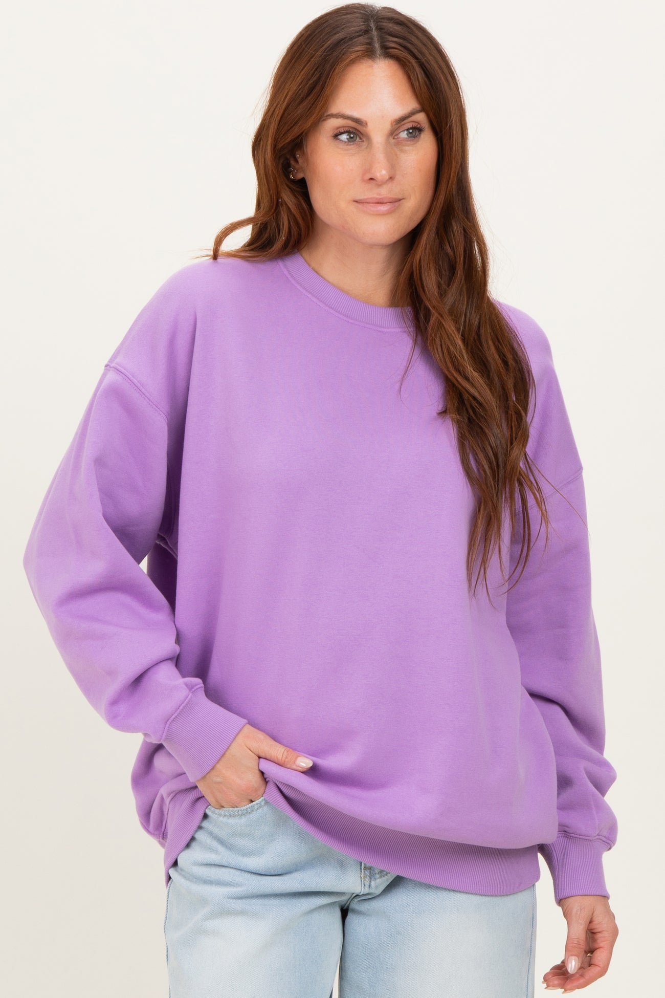 woman wearing a purple oversized sweatshirt with long sleeves and relaxed fit