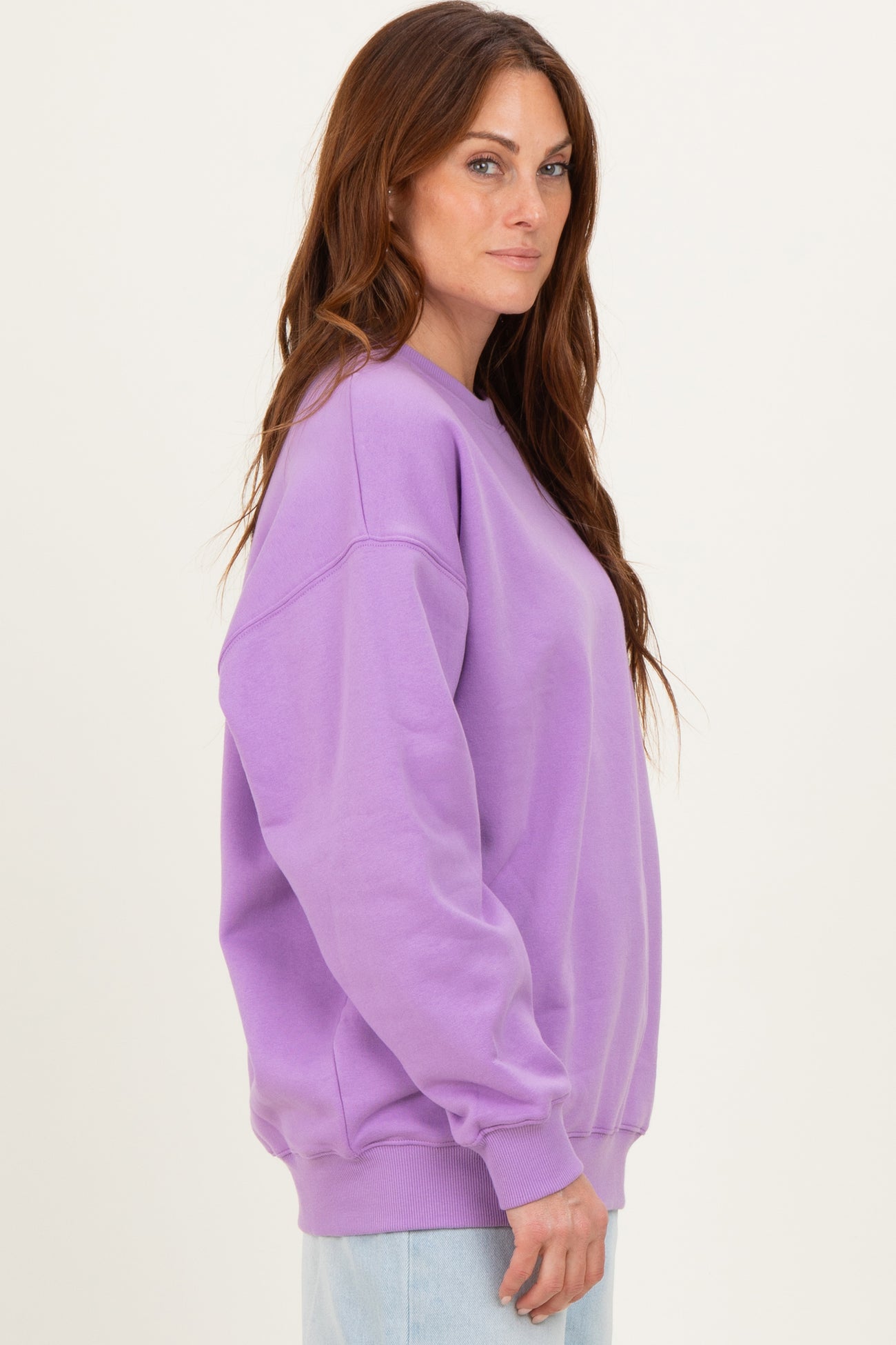 woman wearing a lavender oversized sweatshirt with long sleeves and relaxed fit