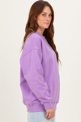 woman wearing a lavender oversized sweatshirt with long sleeves and relaxed fit