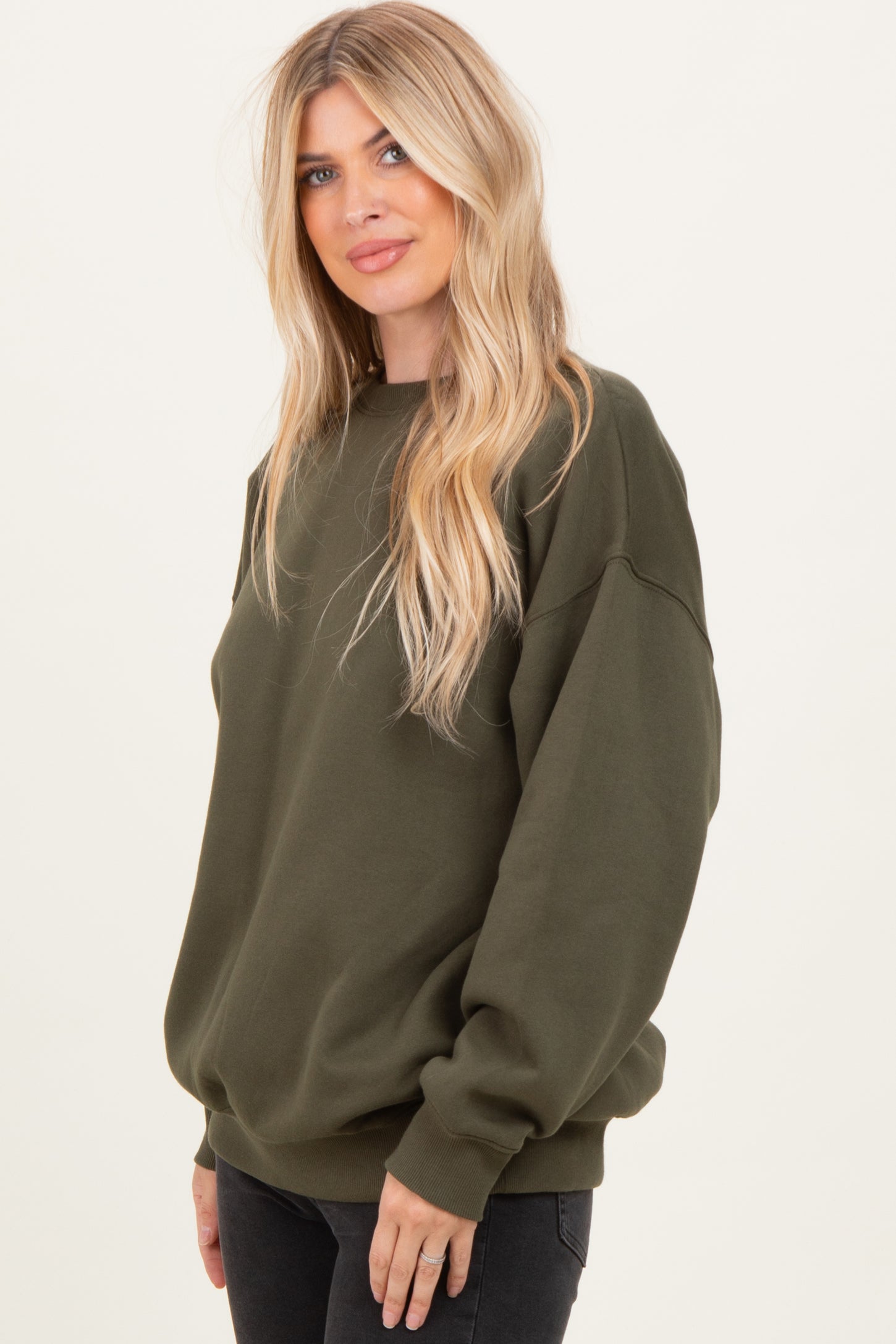 woman wearing an olive green oversized sweatshirt with long sleeves