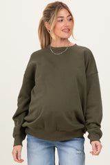 woman wearing a dark green maternity sweatshirt with a relaxed fit and long sleeves