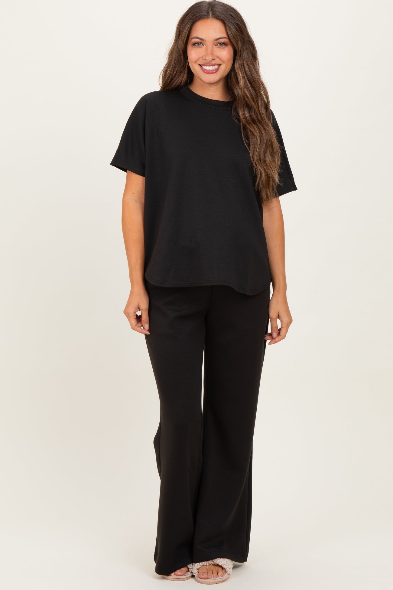 woman wearing a black short sleeve maternity top and matching black wide-leg maternity pants