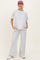woman wearing a gray maternity lounge set with a relaxed top and wide-leg pants, casually posing with hands in pockets