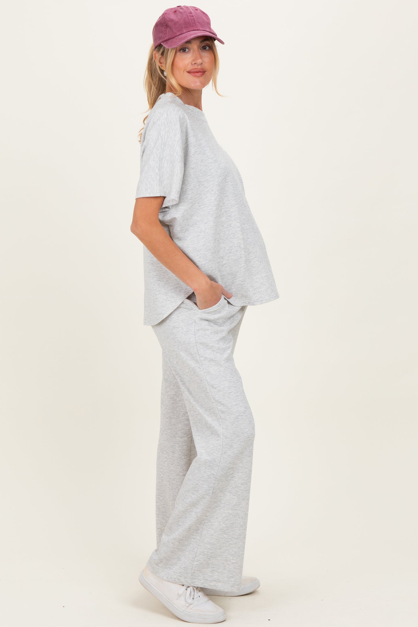 woman wearing a gray maternity loungewear set with a loose top and wide-leg pants, showcasing her baby bump