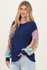 woman wearing a navy blue ribbed top with multicolored patterned balloon sleeves