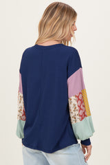 woman wearing a navy ribbed long sleeve top with colorful patterned sleeves