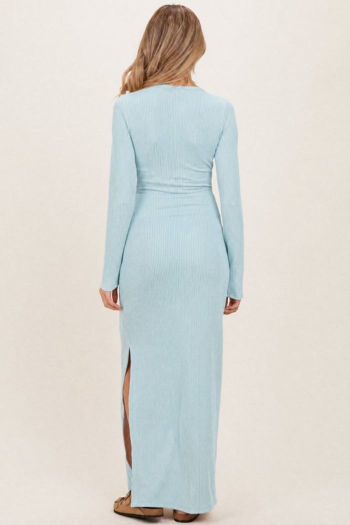 woman wearing a light blue ribbed maternity maxi dress with long sleeves and side slits, viewed from the back