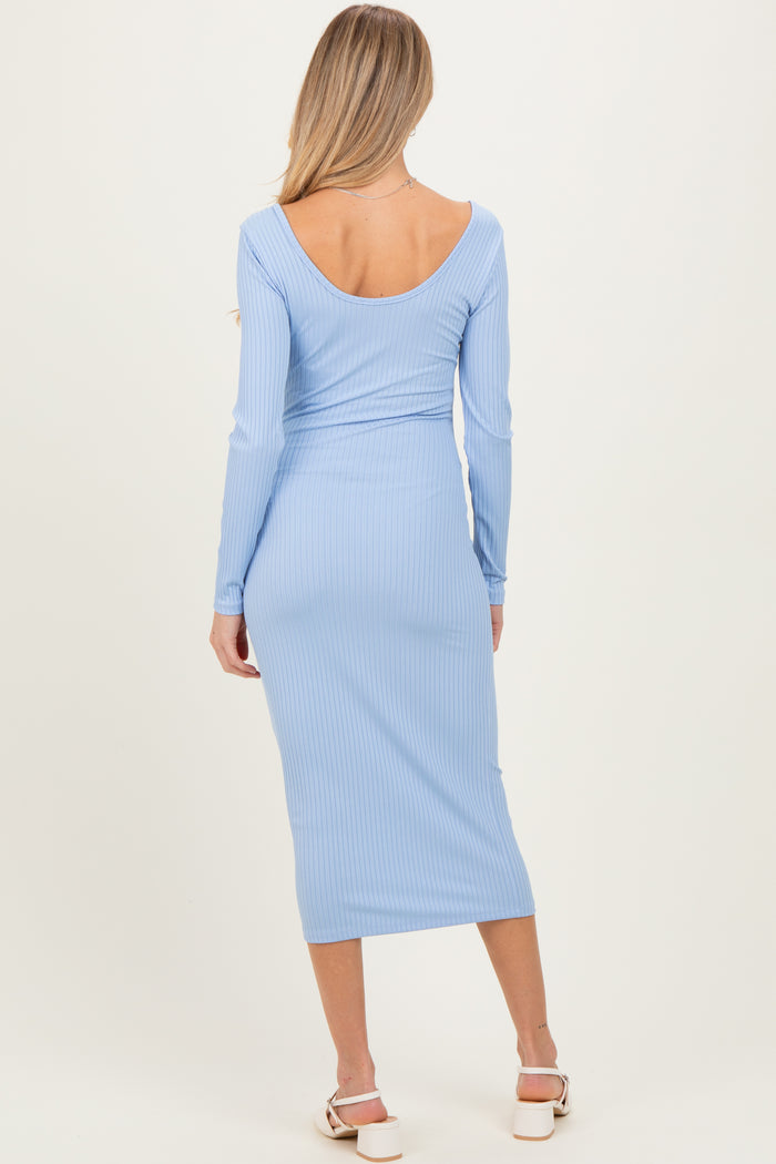woman wearing a light blue ribbed maternity dress with a fitted silhouette and long sleeves, showing a baby bump